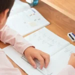 Criança organiza materiais e tarefas durante os estudos em casa