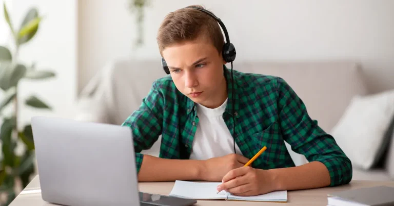 Adolescente concentrado estudando em um notebook, representando a autonomia na aprendizagem discutida pelo PISA 2025